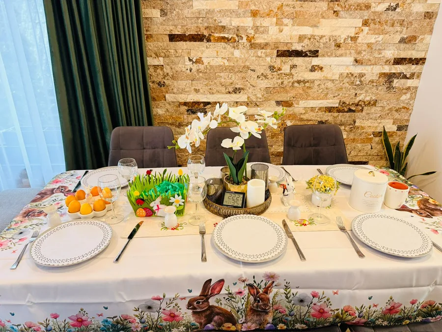 Festive Easter table with themed tablecloth, orchids and bunny decor